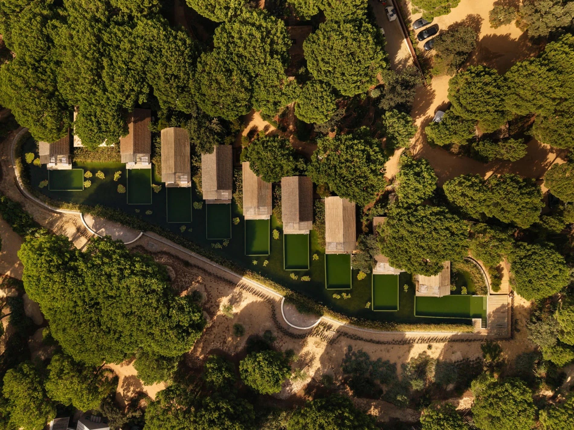 Cabins with their own pools, from the air, in the pines