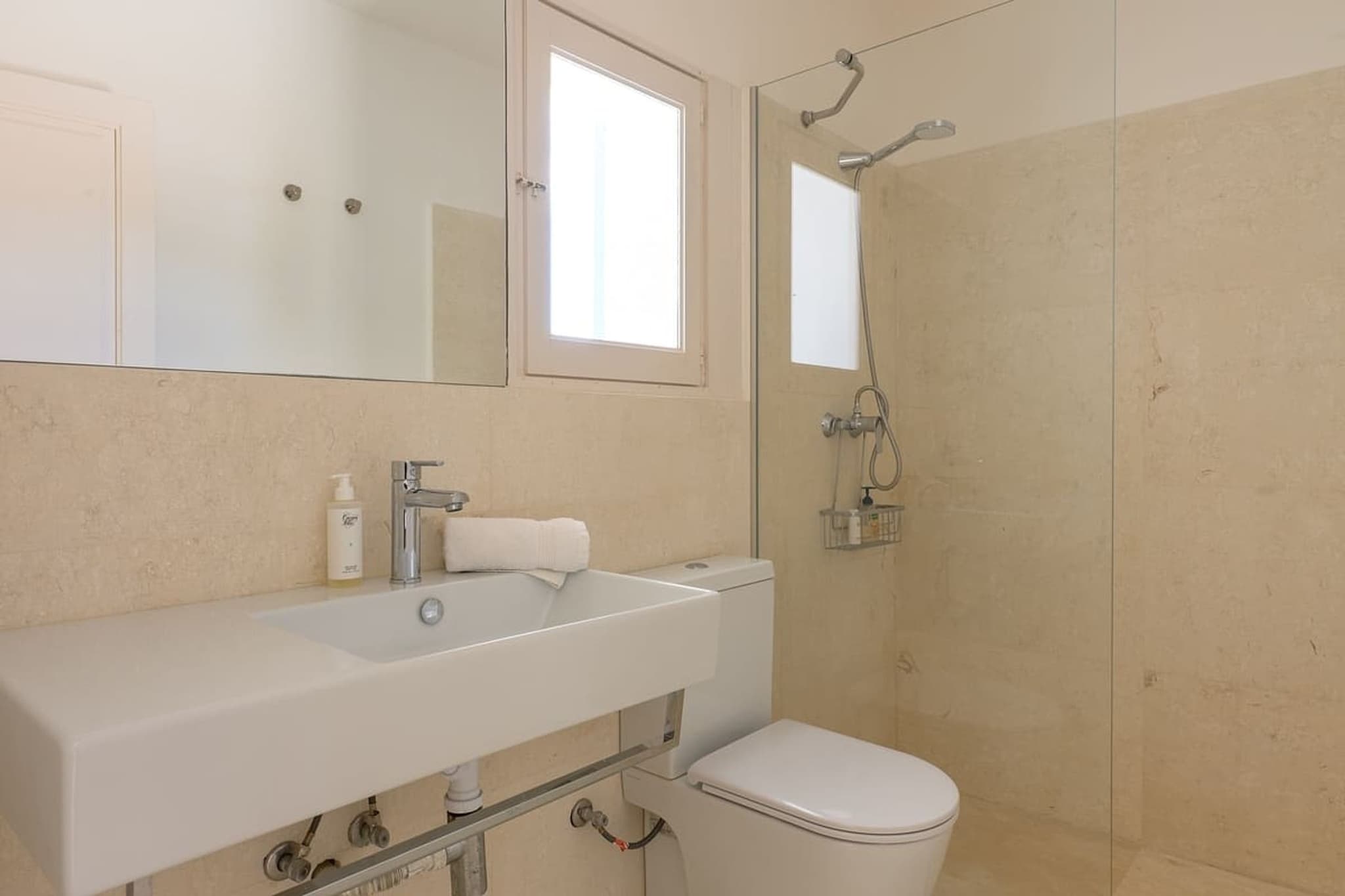 A white sink, the shower behind it