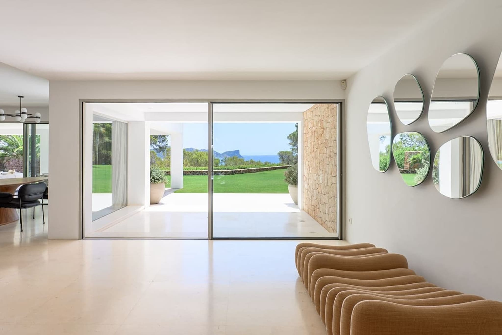 The hallway, mirrors along it, the garden through