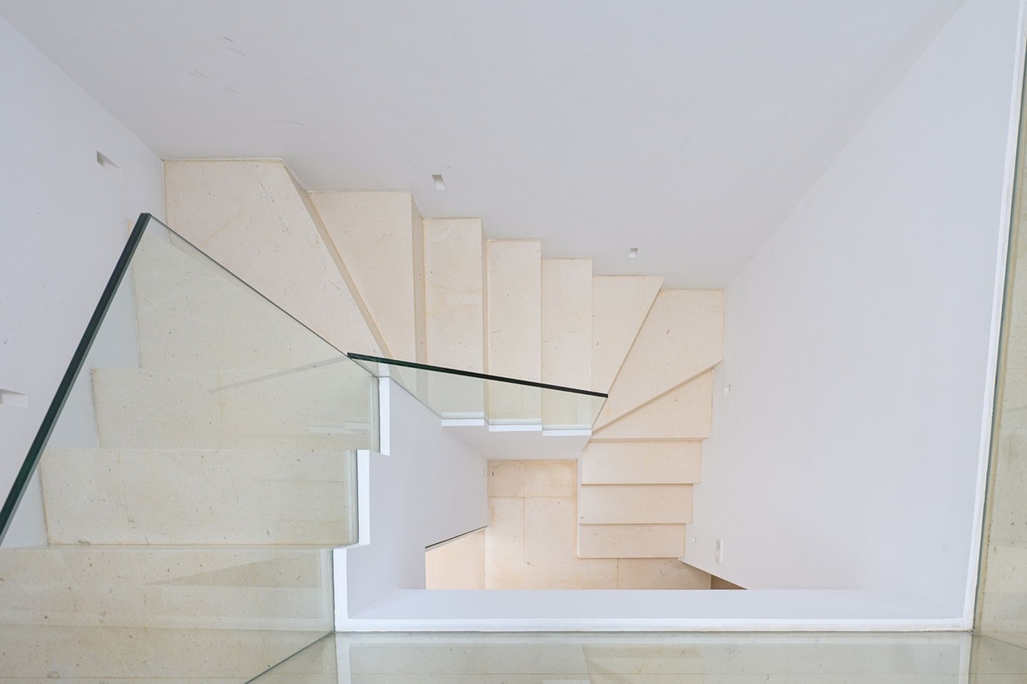 The staircase behind its glass balustrade