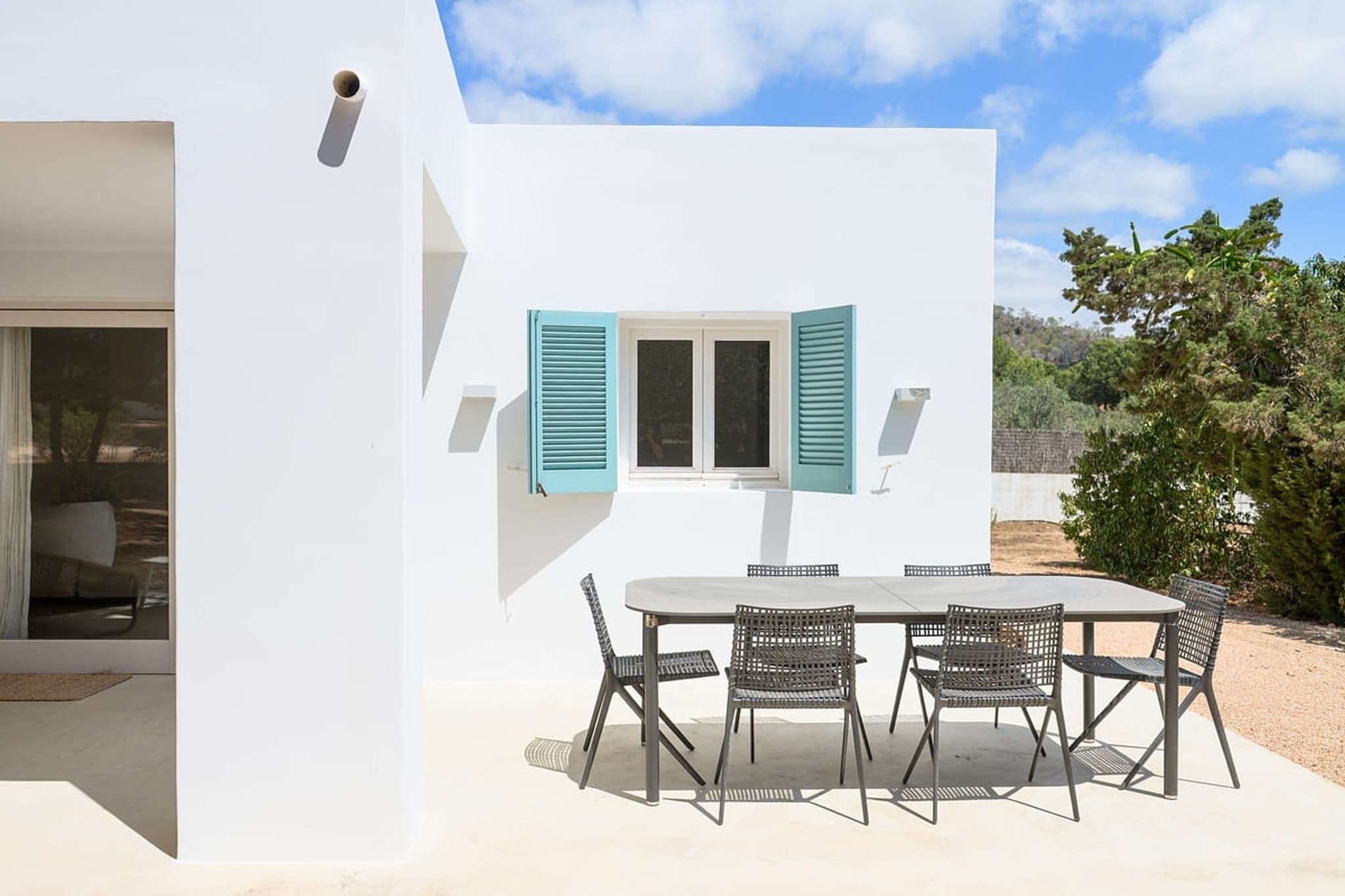 The terrace table, teal shutters behind it