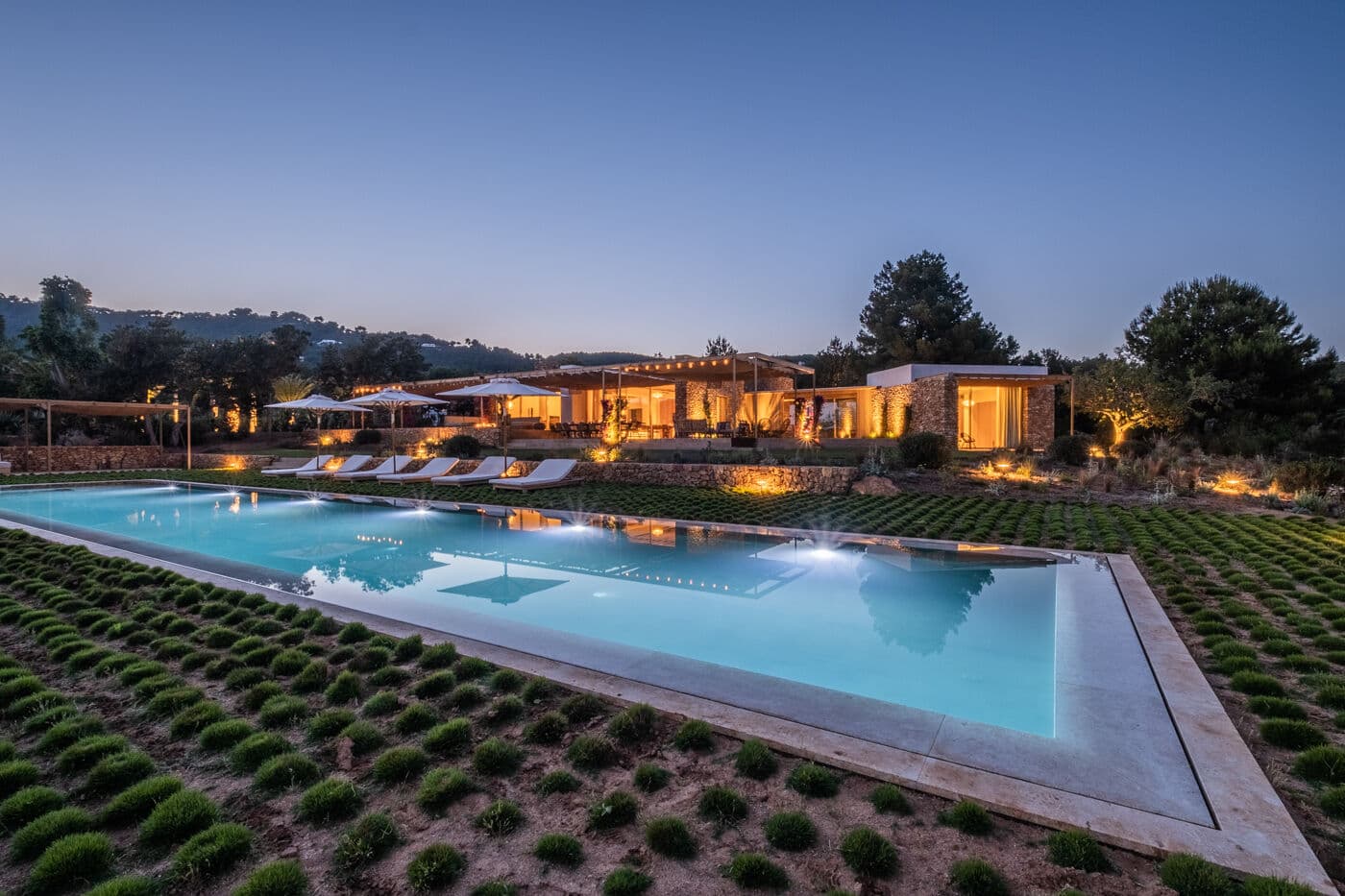 The saltwater pool at dusk, the facade lit behind it