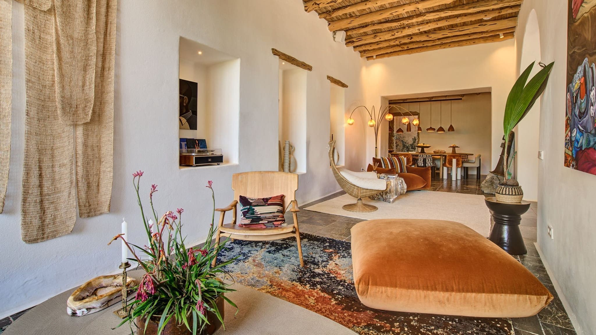 A terracotta ottoman in the living room, artwork behind