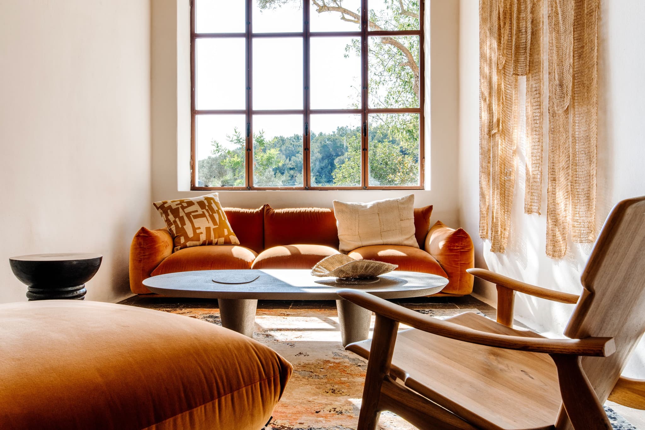 An orange velvet sofa at the window