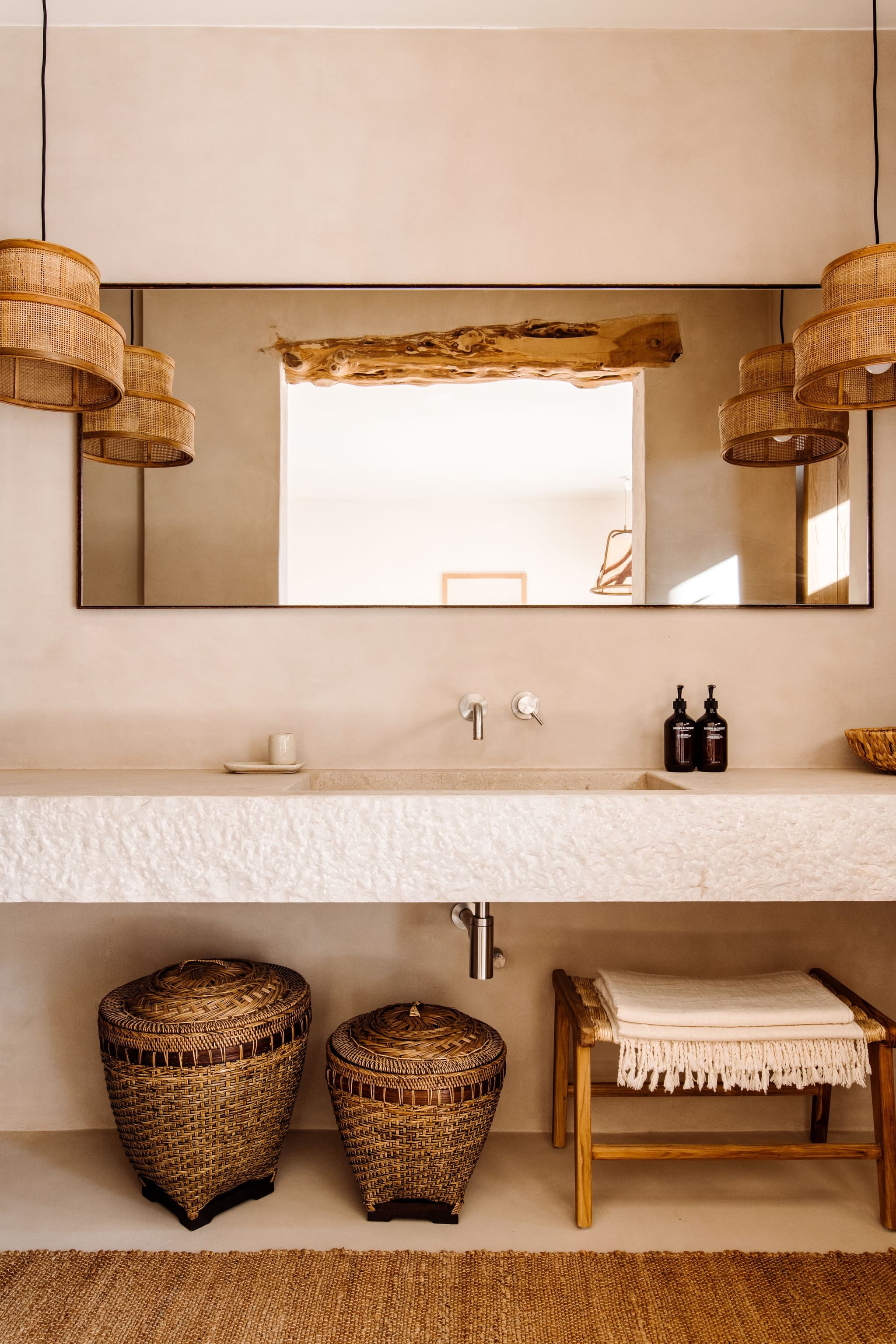 A stone trough sink under a driftwood mirror
