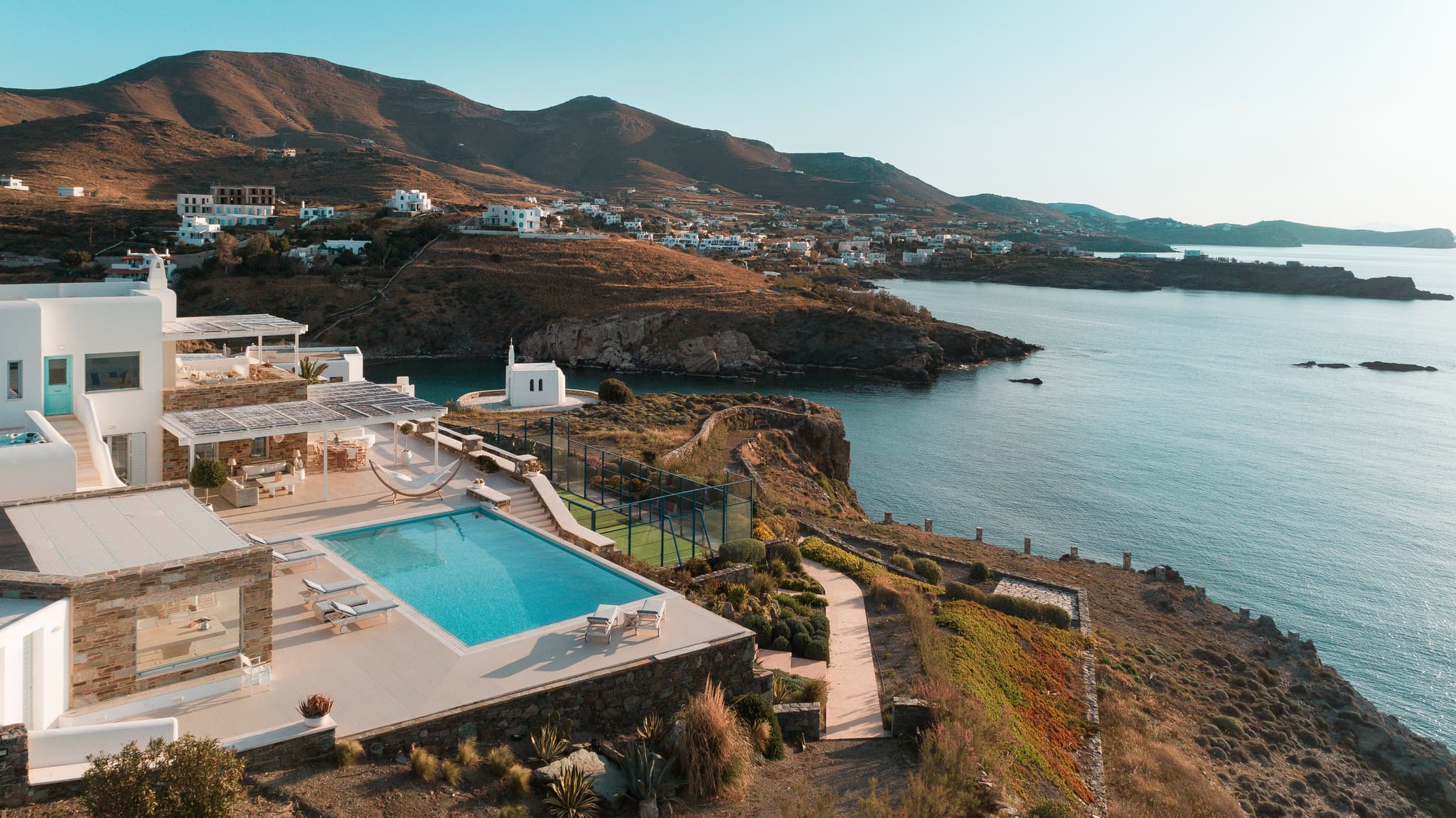 A clifftop villa from the air, the pool and the court above the water