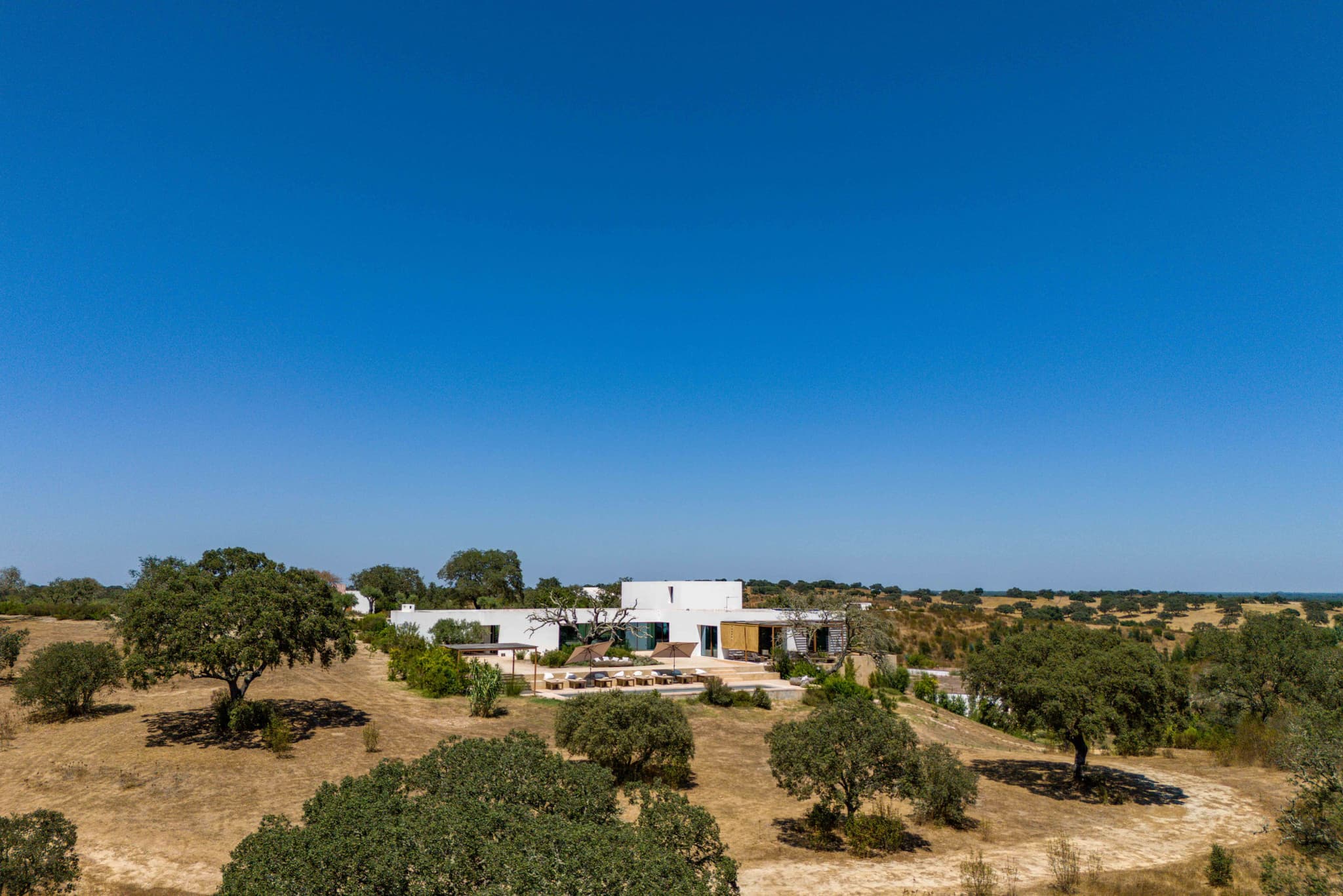 Aerial view whitewashed house cork oak meadow villa quail comporta portugal padel