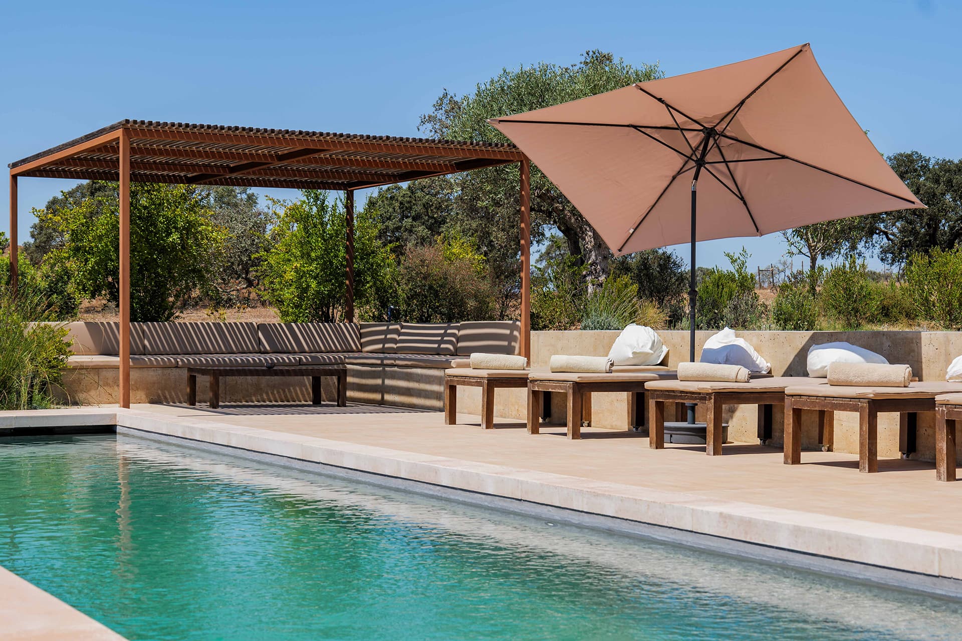 The pool outside, loungers along it