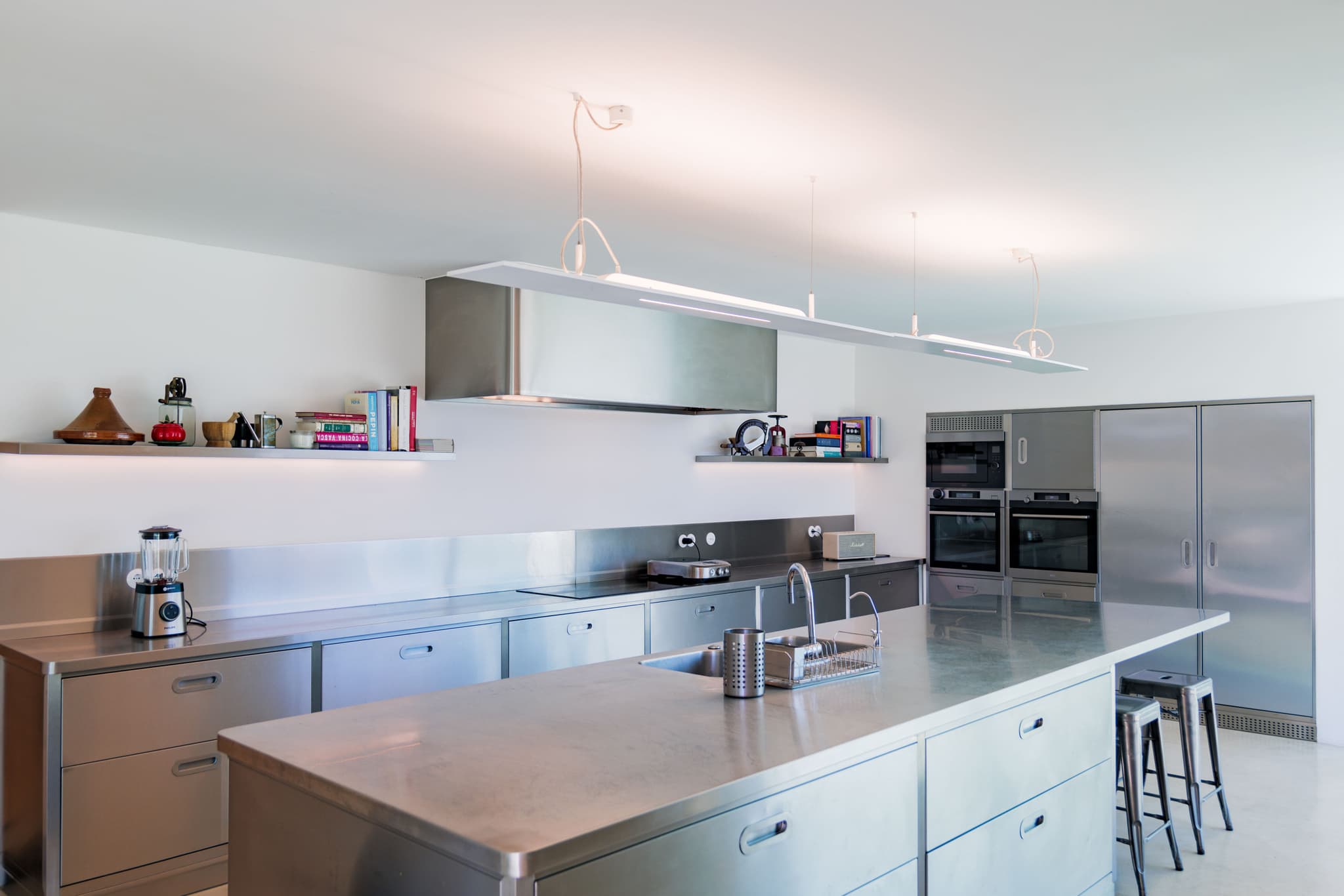 The stainless steel island, with bar stools along it