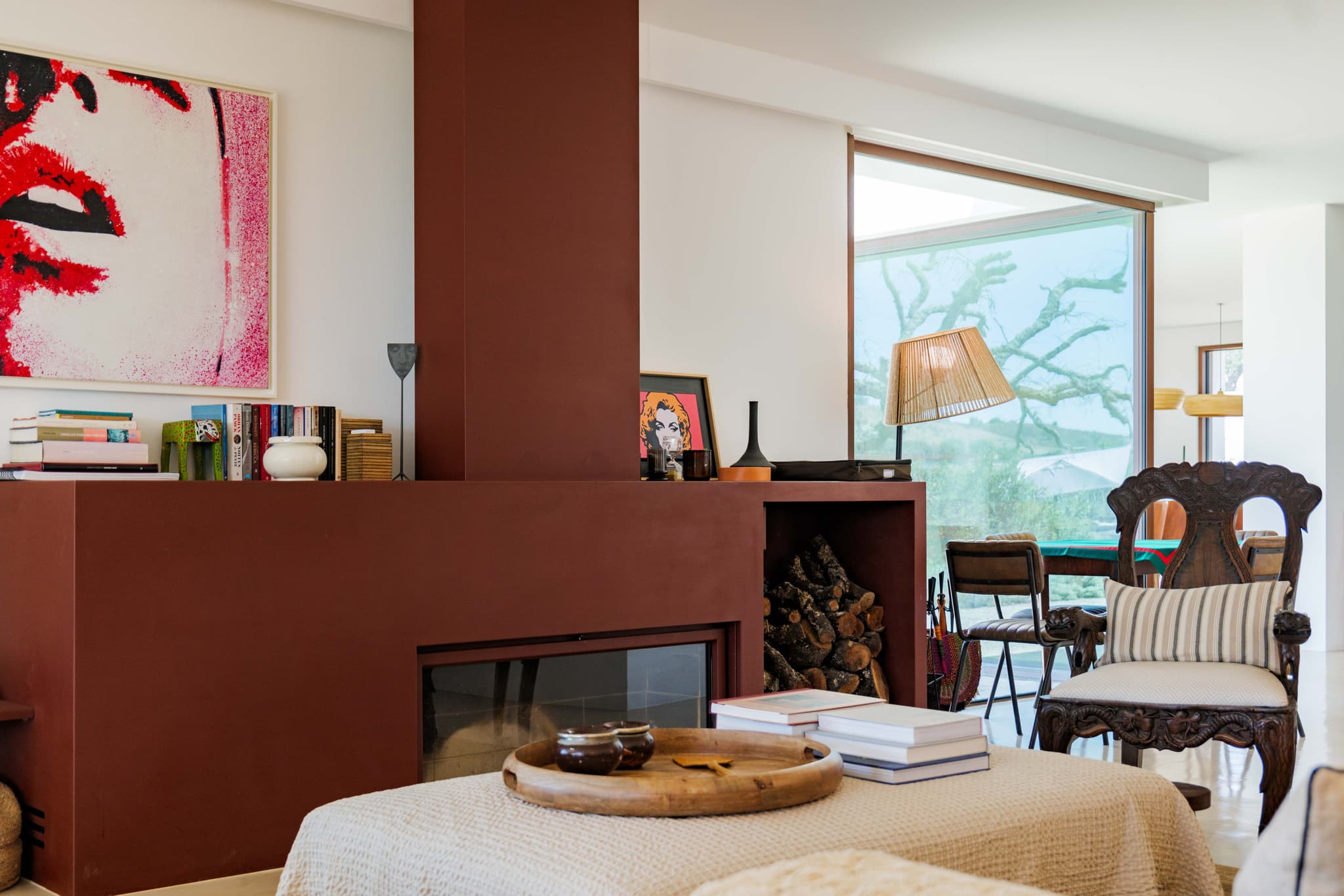 The living room's red fireplace, under the artwork